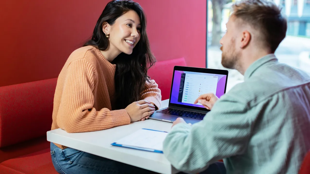 Twee mensen bespreken informatie op een laptop